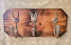 forks and spoons are attached to a wooden plaque