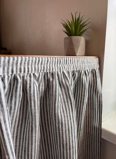 a potted plant sitting on top of a window sill next to a curtain