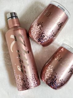 three pink tumblers sitting next to each other on top of a white blanket with the word love written on them