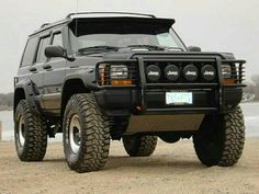 a black suv parked on top of a sandy beach