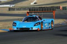 a blue race car driving on a track