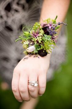 a close up of a person's hand holding flowers