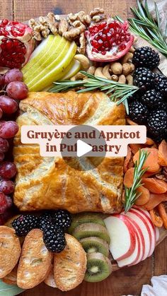 a platter filled with fruit, bread and nuts on top of a wooden table