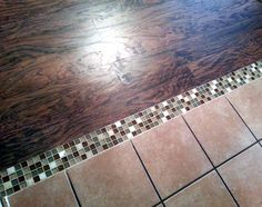 a bathroom floor with tile and wood in it