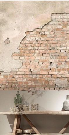 an old brick wall is shown behind a wooden table