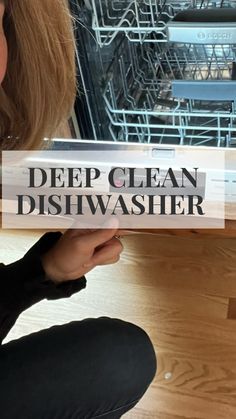 a woman is sitting on the floor with her dishwasher