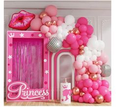 a pink room with balloons and decorations on the wall