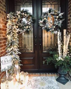 two christmas wreaths on the front door of a house