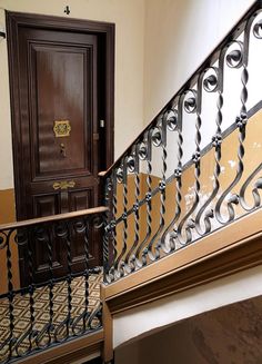 an open door is on the side of a stair case next to a wooden door