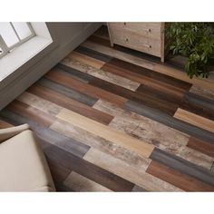 a wooden floor with different colors and patterns on it, next to a white chair