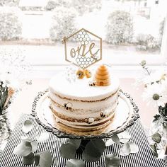 a cake sitting on top of a black and white checkered table cloth next to flowers