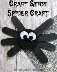 a spider craft made out of black paper with googly eyes on it's head