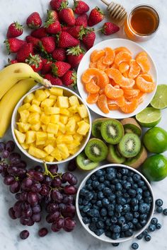 various fruits and vegetables are arranged in bowls