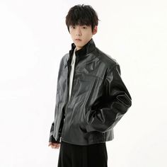 a young man wearing a leather jacket and black pants standing in front of a white background