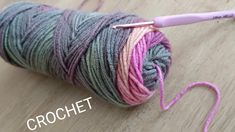 a ball of yarn with a crochet hook on the end and pink thread