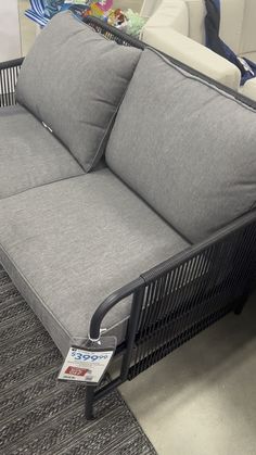 a gray couch sitting on top of a carpet covered floor