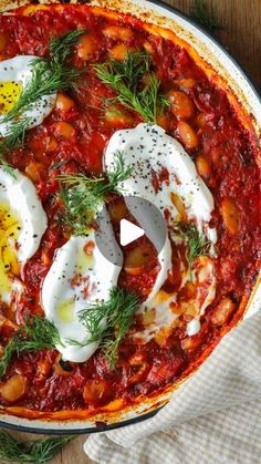 an overhead view of a baked dish with eggs and tomato sauce