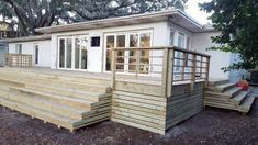 a mobile home with steps leading up to the front door and windows on each side