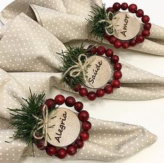 two napkins with red berries and pine cones on them, tied in twine