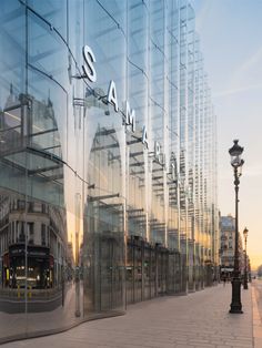 an image of a city street that is reflected in the glass building windows and lampposts