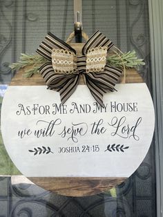 a wooden sign with a bow hanging from it's front door saying as for me and my house we will serve the lord