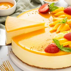 a cheesecake with strawberries and oranges on the top is ready to be eaten