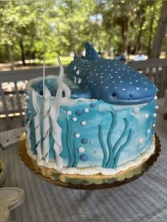 a blue and white cake sitting on top of a wooden table covered in frosting