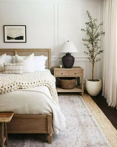 a bedroom with white walls and wooden furniture