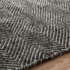 a black and white area rug on top of a wooden floor next to a hardwood floor