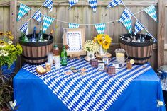 a blue and white checkered table cloth topped with wine bottles, flowers and other items