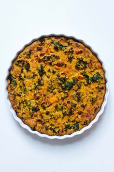 a quiche with broccoli, cheese and other toppings in a pie pan