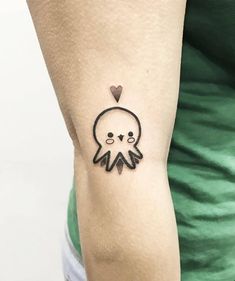 an octopus tattoo on the arm with a heart in it's head and eyes