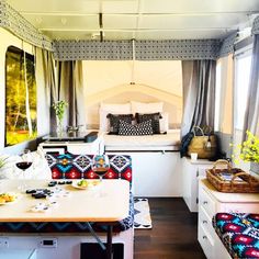 a bed sitting in the middle of a bedroom next to a table with food on it