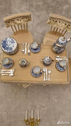 a doll house table set with china and silverware