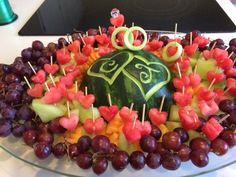 a watermelon and grapes are arranged in the shape of a woman's face