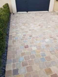 a brick driveway with two garage doors on each side