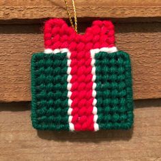 a crocheted christmas ornament hanging on a wooden door frame with a chain