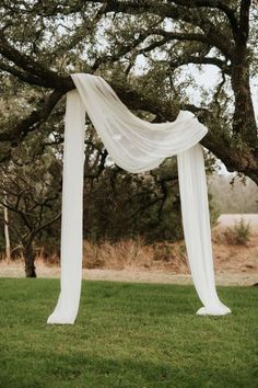 a white drape draped over an outdoor ceremony arch