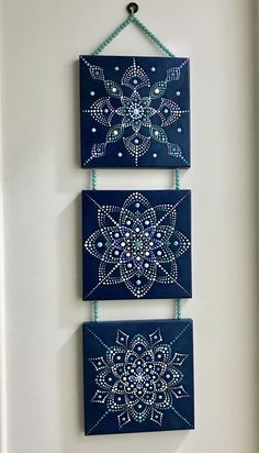 two blue wall hangings with beaded designs on them