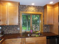 a kitchen with wooden cabinets and granite counter tops, along with a stainless steel dishwasher