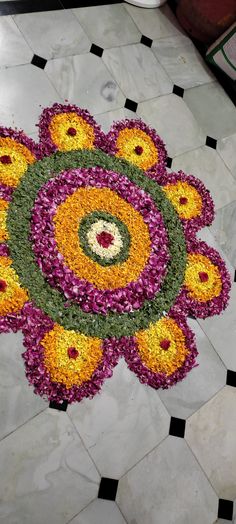 a colorful flower arrangement on the floor with black and white tiles in the background,