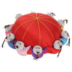 a red round cushion with many small stuffed animals around the edges and on it's sides