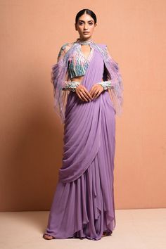 Lavender pre-stitched saree with pleated pallu and drape detail. Paired with asymmetric pleated tulle drape and linear ombre artwork hand embellished pearl and bugle bead work blouse.
Component: 2
Embellished
Neckline: High neck
Sleeve Length: Full
Fabric: Georgette
Color: Purple

Sheer back
Closure
Blouse: Back zip - Aza Fashions Traditional Outfit Ideas, Lavender Saree, Lavender Gown, Gradient Art, Lavender Fabric, Wedding Outfits For Women, Blouses Designs, Saree Gown, Drape Saree