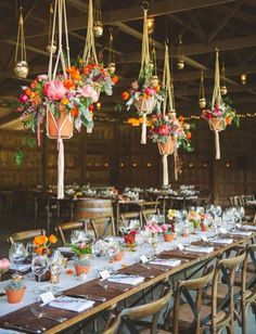 the tables are set with flowers and hanging vases