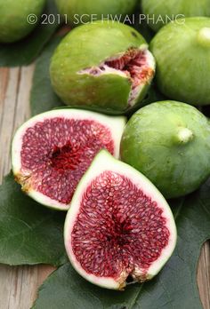 green and red fruit sitting on top of leaves