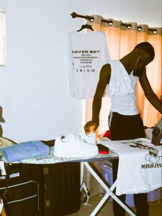 a man ironing clothes on an ironing board