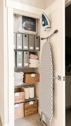 an ironing board and some baskets in a closet