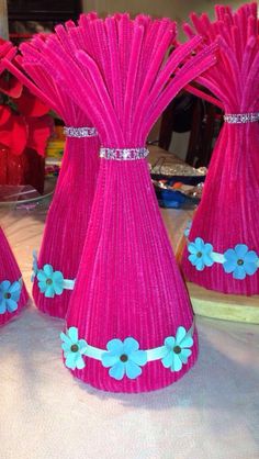 three pink vases with blue flowers on them