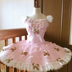 a pink and white dress sitting on top of a wooden table