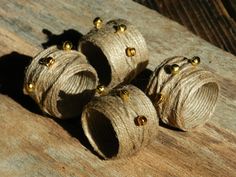 four wooden beads are sitting on a piece of wood